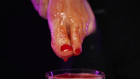 Tomato juice flows down woman's beautiful red pedicure leg into glass of ice Stock Footage 168973500