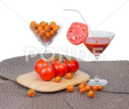 Tomato juice in the glass, orange cherry tomatoes and red tomatoes on vine is Stock Photos
