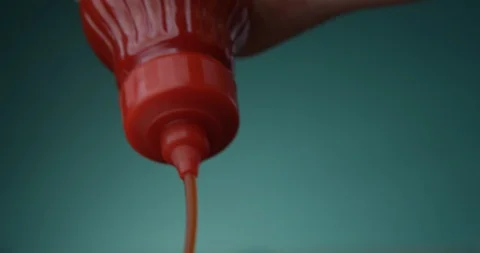 Tomato Ketchup is Squeezed From a Red Bottle a Closeup on a Biscay Green Stock-Footage 121814681