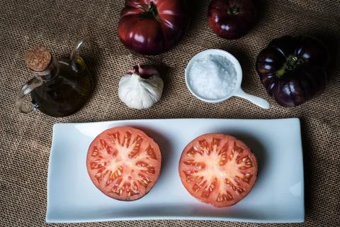 Tomato of the Mar Azul variety, split in half and presented on a plate Stock Photos