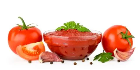 Tomato paste in glass plate, tomatoes, garlic and pepper on a white background Stock Photos