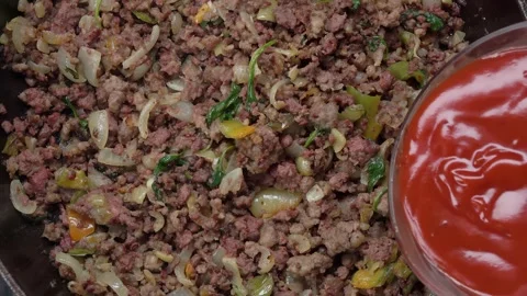Tomato paste is poured into a frying pan on which ground beef is fried Stock-Footage 292682739