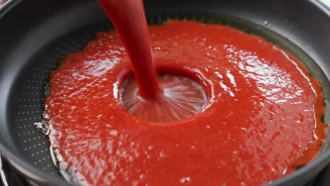 Tomato paste pours into frying pan with cooking oil. Concept of preparing sauce Stockbeeldmateriaal 341604204