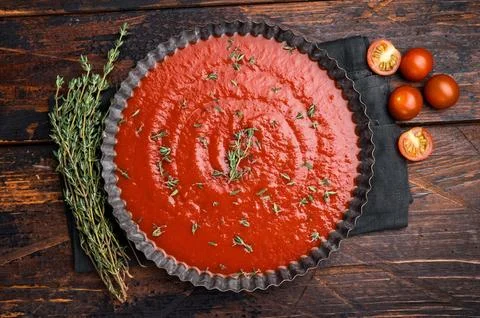 Tomato paste sauce with thyme in plate, canned food for cookng. wooden back.. Stock Photos