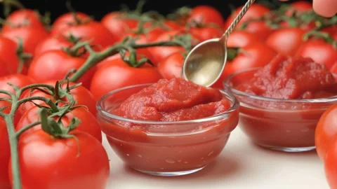 Tomato paste is spooned, a natural cooking sauce made from tomatoes. Stock-Footage 314319234
