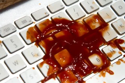 Tomato puree falling on the computer keyboard Stock Photos