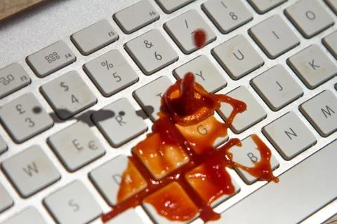 Tomato puree falling on the computer keyboard Stock Photos