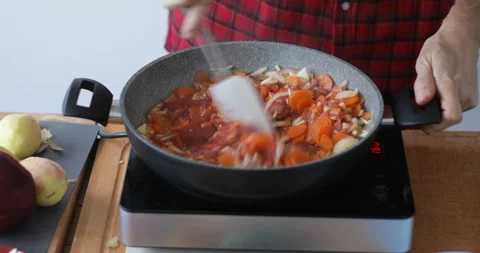 Tomato puree mixed with boiling root vegetables in hot pan Stock Footage 146246865
