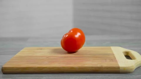 A tomato rolls on a cutting board Video stock 196725779
