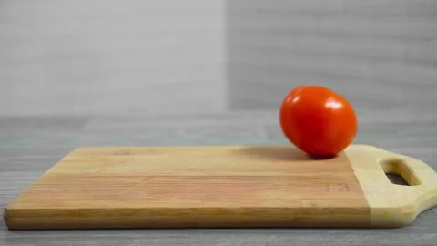 A tomato rolls on a cutting board Video stock 196725798