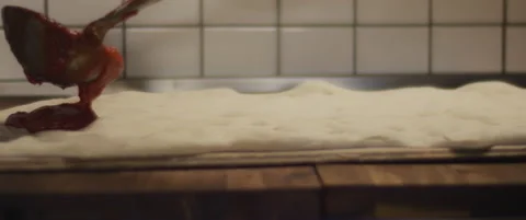 Tomato sauce being spread over a fresh pizza dough. Close up, super slow moti Stock Footage 146607030
