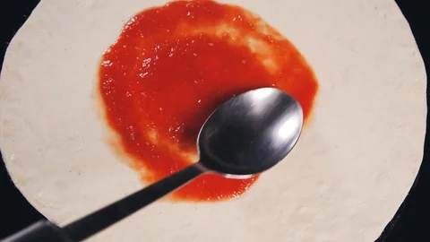 Tomato sauce is put on the pizza. Stock Footage 112595622