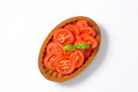 Tomato slices in a bread bowl with basil Stock Photos