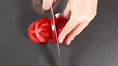 Tomato slicing on gray background close-up top view Video stock 132598633