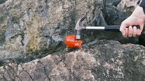 Tomato is smashed with a hammer in a man hand, slow motion Stock Footage 165342699