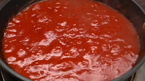 Tomato soup is boiling in a pan. Boiling bubbles on tomato sauce. Close up, top 스톡 동영상 164544463