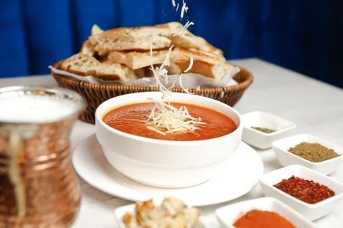 Tomato soup served with bread and spices in a restaurant setting 库存照片