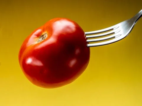 Tomato with yellow background Stock Photos