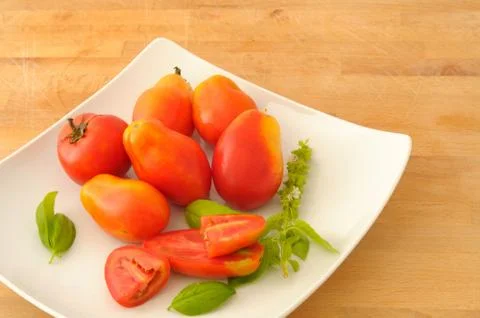 Tomatoes and basil in a square dish Stock Photos