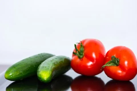 Tomatoes and cucumbers on the kitchen table Stock Photos