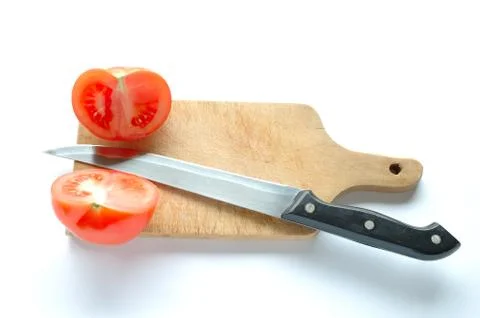 Tomatoes and knife on chopping board on white background Stock Photos