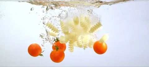 Tomatoes and pasta falling in clean water Stock Footage 323437535