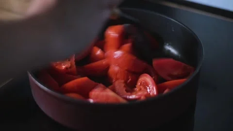 Tomatoes are being stirred in a pan as they cook over heat. This kitchen Vidéo 344667352