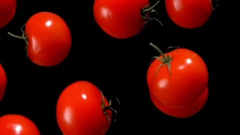 Tomatoes are falling down on on a black background Stock Footage 102383840