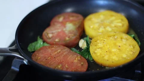 Tomatoes with basil being cooked in a pan, home cooking, 4k, real time Stockbeeldmateriaal 248542269