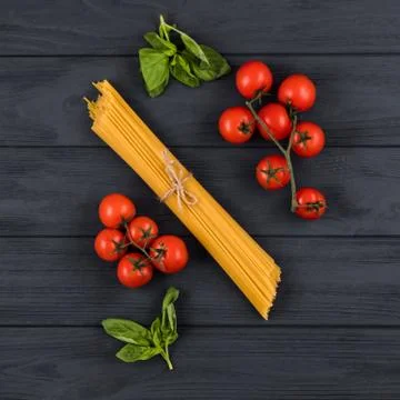 Tomatoes, basil, spaghetti. Top view. Concept of Italian cuisine. Stock Photos