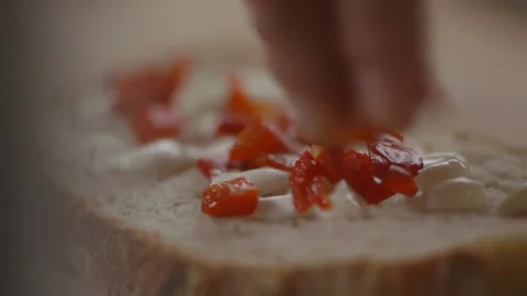 Tomatoes being sprinkled onto bread Stock Footage 194478449