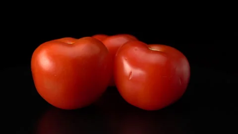 Tomatoes on a black background close-up. Video stock 147853240