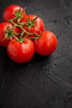 Tomatoes on black background. Stock Photos