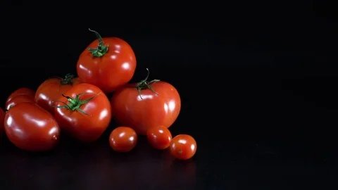 Tomatoes on black background, sliding Video stock 75779105