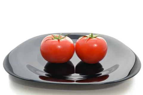 Tomatoes on a black plate Foto stock