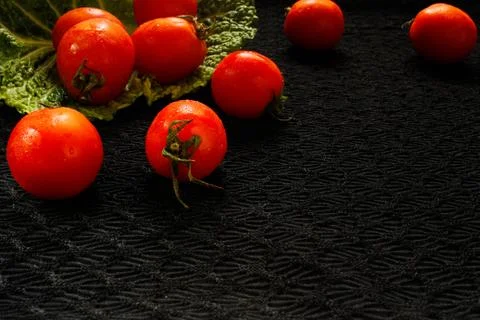Tomatoes on a black surface, side view Stock Photos