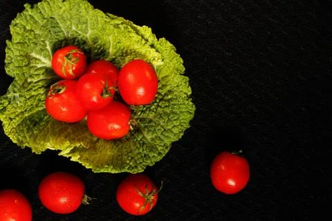 Tomatoes on a black surface, top view Stock Photos