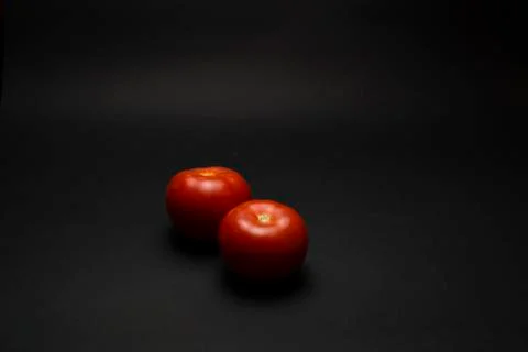 Tomatoes on a black table Stock Photos