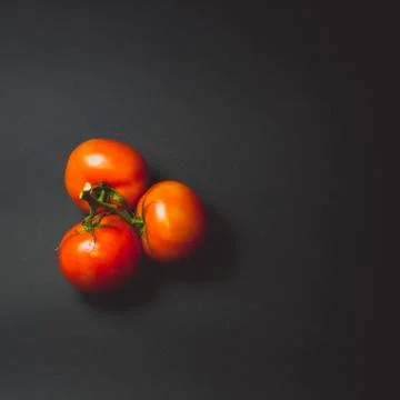 Tomatoes on a black table Stock Photos