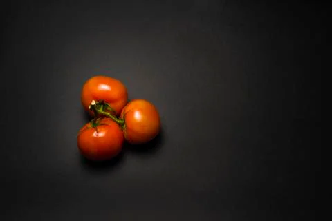 Tomatoes on a black table Stock Photos