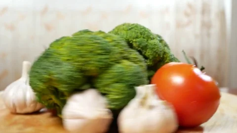 Tomatoes, broccoli and garlic, rotating on a wooden cutting board. 4k. Stock-Footage 84193407