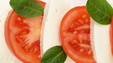 Tomatoes, cheese, spinach leaves - background. Video stock 168735218