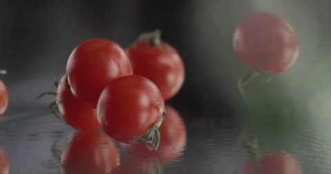 Tomatoes cherry fall on a mirror surface Stock Footage 198560632