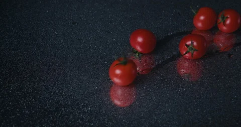Tomatoes closeup falling in water with Splash droplets on black background macro Stock Footage 142235530