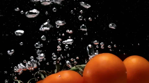 Tomatoes cluster falls down into water on black background 스톡 동영상 145716244