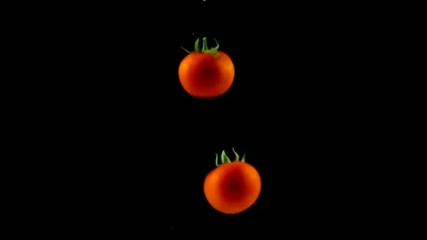 Tomatoes coming down by turning the water in the dark Stock Footage 108125672