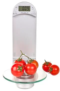 Tomatoes on electronic kitchen scales Stock Photos