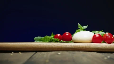 Tomatoes fall down onto mozzarella and basil slow motion Stock-Footage 120166942