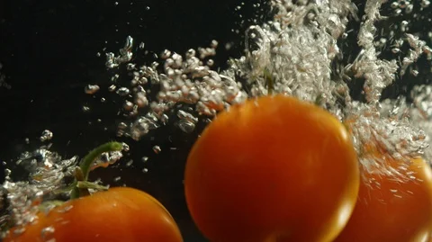 Tomatoes fall down into water Stock Footage 127837662