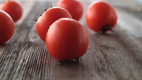 Tomatoes falling and rolling on a table. Slow Motion. Stock Footage 84929229